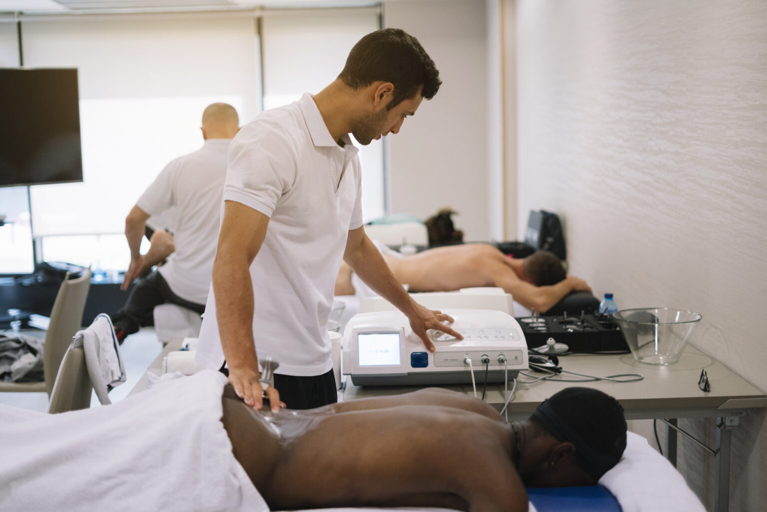 The physiotherapist treating a man using equipment