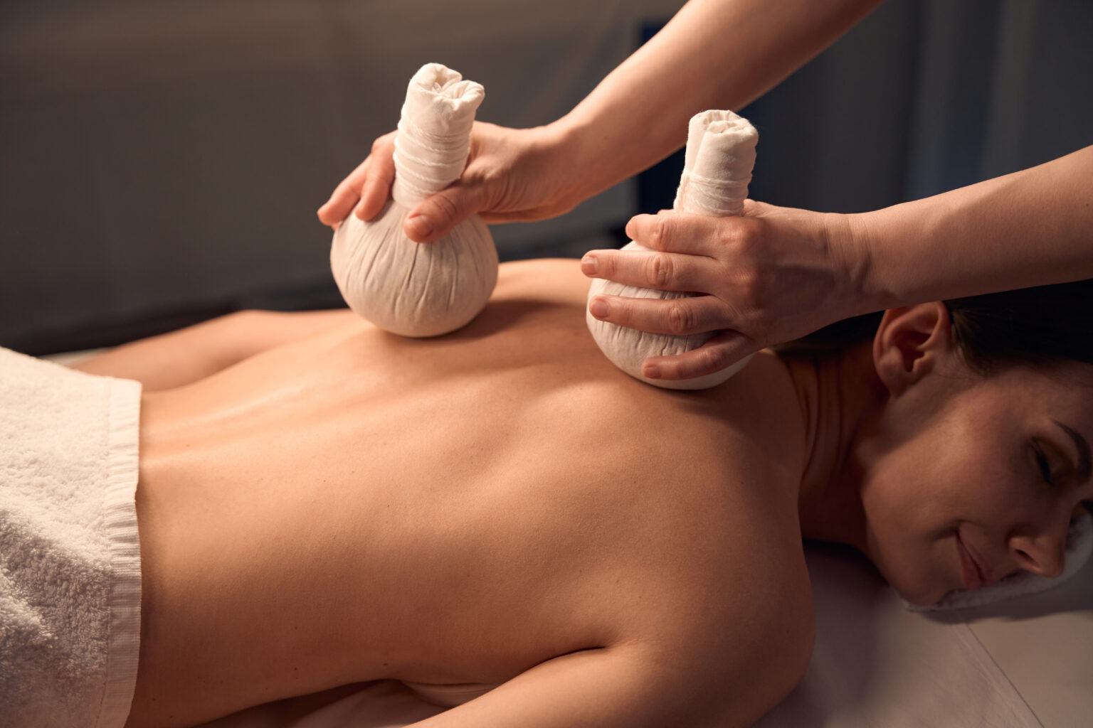 Woman dozing during hot compress massage performed